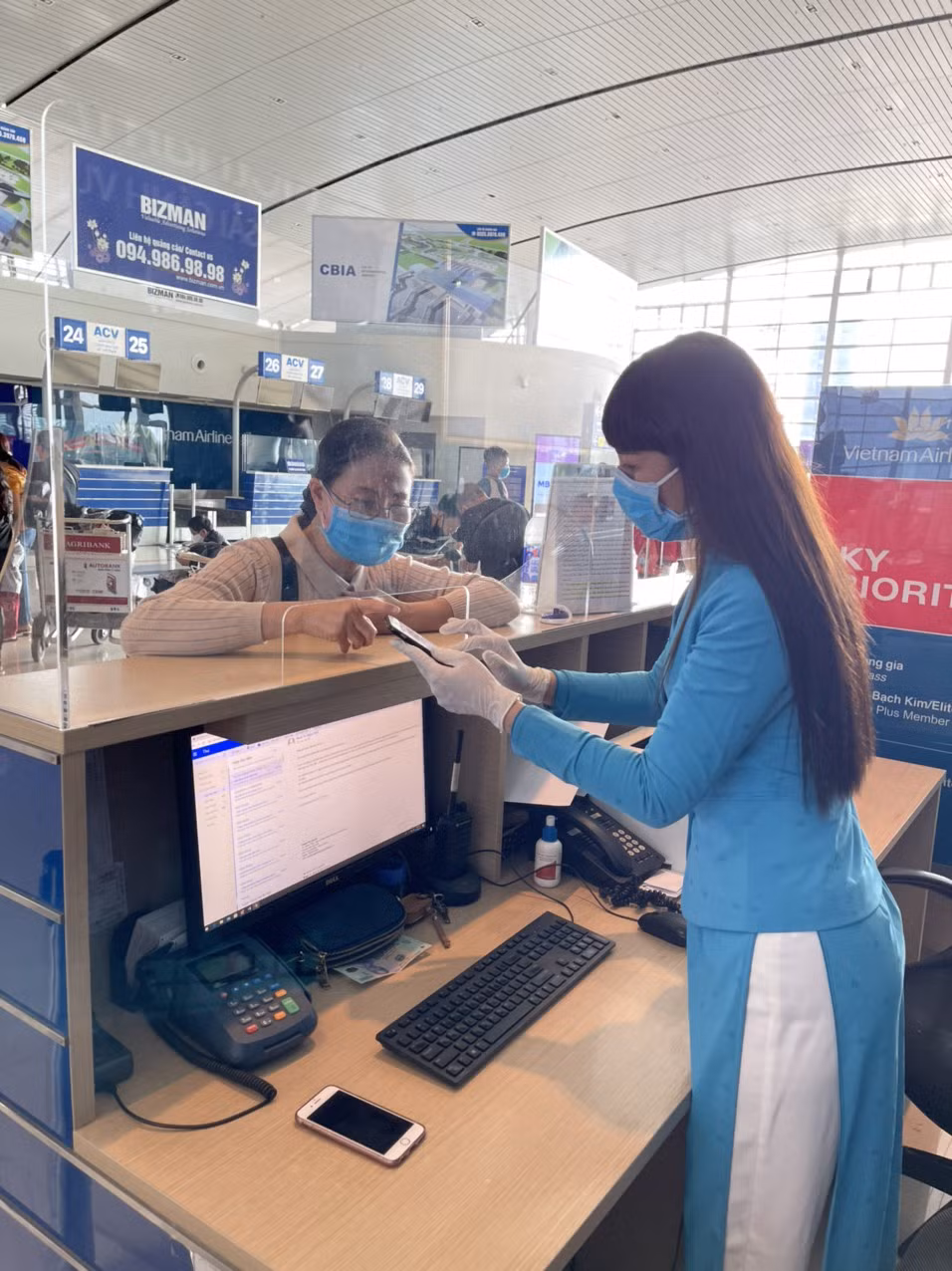 Nhân viên mặt đất của Vietnam Airlines hướng dẫn hành khách làm thủ tục. (Ảnh: CTV/Vietnam+)