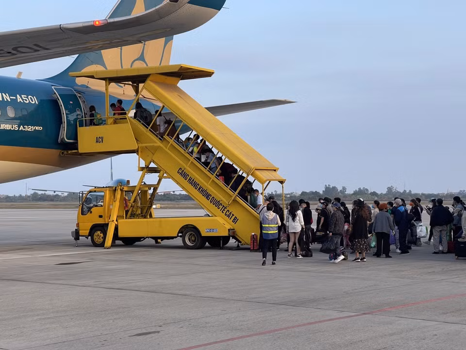 Hành khách đeo khẩu trang lên tàu bay. (Ảnh: CTV/Vietnam+)