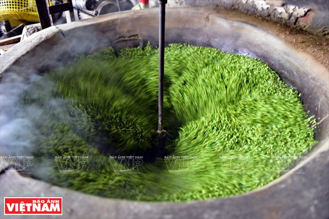 Theo kinh nghiệm của người dân nơi đây, cốm được rang trong lửa nhỏ, đảo liên tục cho nóng đều. (Nguồn: Báo ảnh Việt Nam)