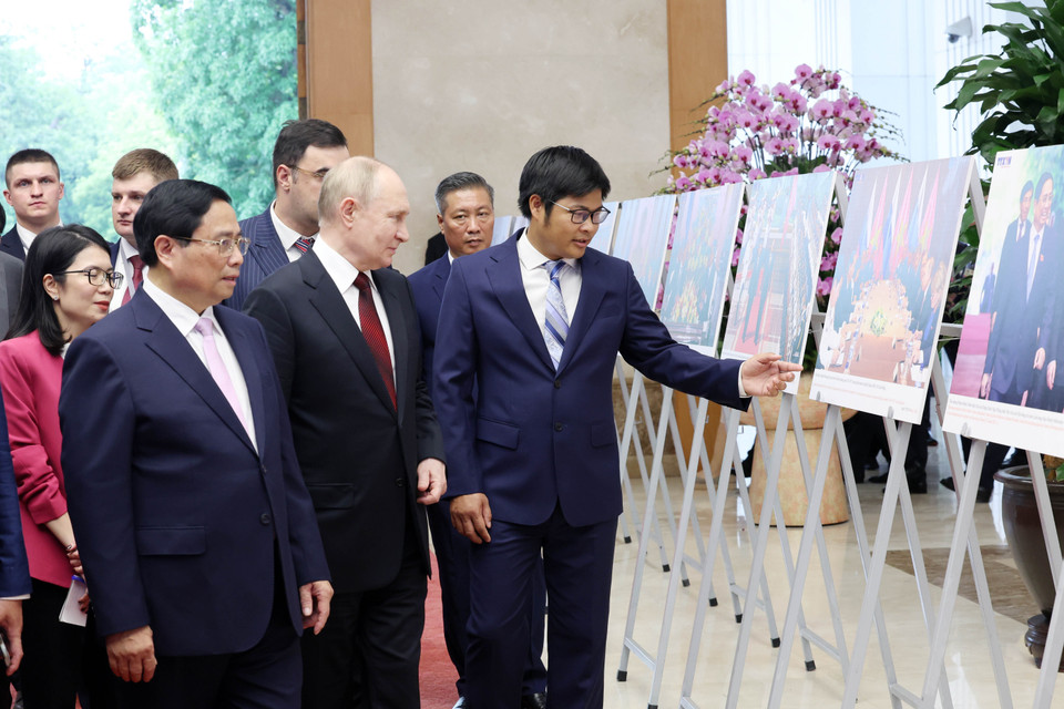 Thủ tướng Phạm Minh Chính và Tổng thống Liên bang Nga Vladimir Putin xem trưng bày ảnh về quan hệ Việt Nam-Nga. (Ảnh: Dương Giang/ TTXVN)