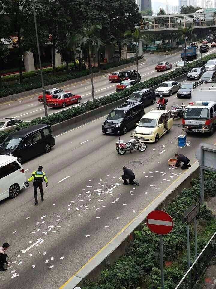 Một nhân chứng cho biết, hàng chục người đã tới nhặt hàng trăm tờ tiền mệnh giá 500 đô la Hong Kong (khoảng 65 USD) bay trên đường. (Nguồn: CCTV)