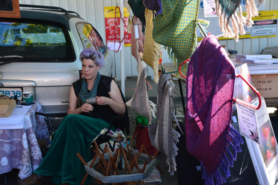 Một “nhà thời trang đường phố” đang tự tay dệt những chiếc khăn do chính bà thiết kế. (Ảnh: Võ Giang/Vietnam+)