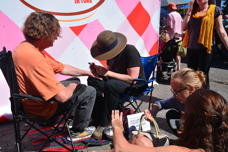 "Họa sỹ đường phố” trang trí họa tiết trên tay du khách. (Ảnh: Võ Giang/Vietnam+)