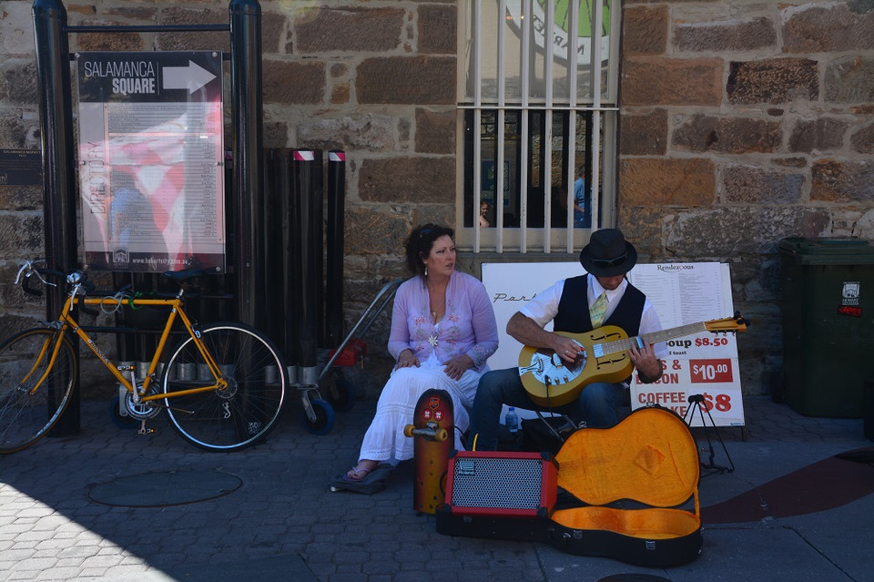 Người đàn ông chơi guitar còn người phụ nữ hát. Thùng đàn dưới chân họ dùng để đựng tiền người qua lại cho. (Ảnh: Võ Giang/Vietnam+)