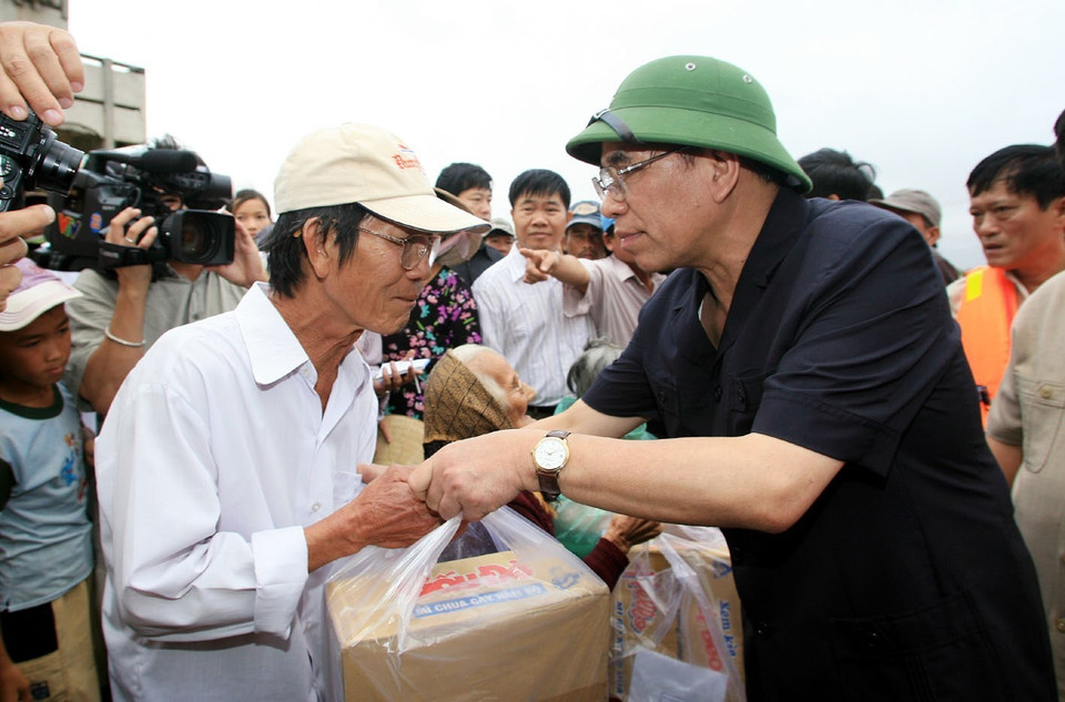 Tổng Bí thư Nông Đức Mạnh thăm và tặng quà các gia đình chính sách thôn Diêm Vân, xã Phước Thuận, huyện Tuy Phước, tỉnh Bình Định, bị thiệt hại do cơn bão số 11, ngày 5/11/2009. (Ảnh: Đinh Xuân Tuân/TTXVN)