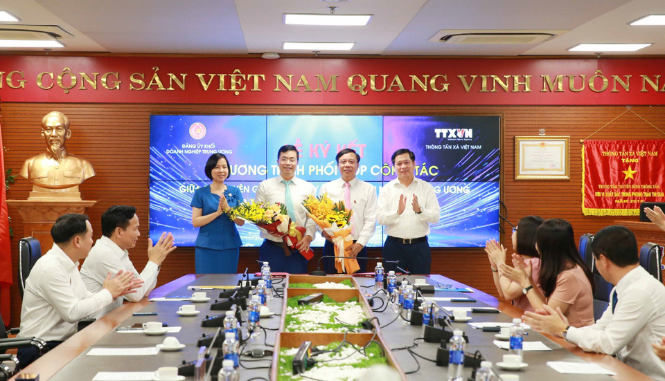 Bí thư Đảng ủy Khối Doanh nghiệp Trung ương Nguyễn Long Hải và Tổng Giám đốc Thông tấn xã Việt Nam Vũ Việt Trang tặng hoa hai đơn vị. (Ảnh: Phương Hoa/TTXVN)