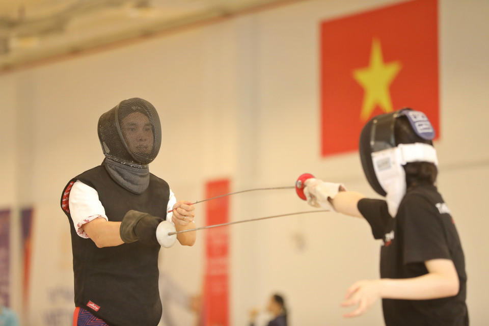 HLV trưởng đổi tuyển đấu kiếm Việt Nam Nguyễn Tiến Việt hướng dẫn, truyền đạt các kỹ thuật nội dung kiếm liễu cho vận động viên Nguyễn Thị Thu Phương. (Ảnh: Minh Quyết/TTXVN)