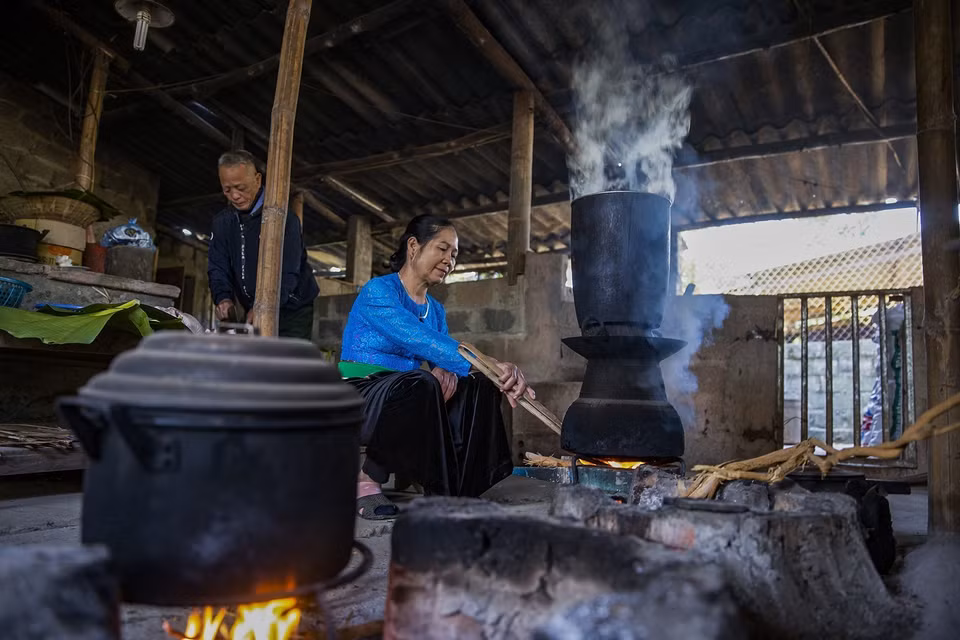 Một gia đình người Mường tất bật chuẩn bị đồ cúng đón mừng năm mới. (Ảnh Trọng Đạt/TTXVN)