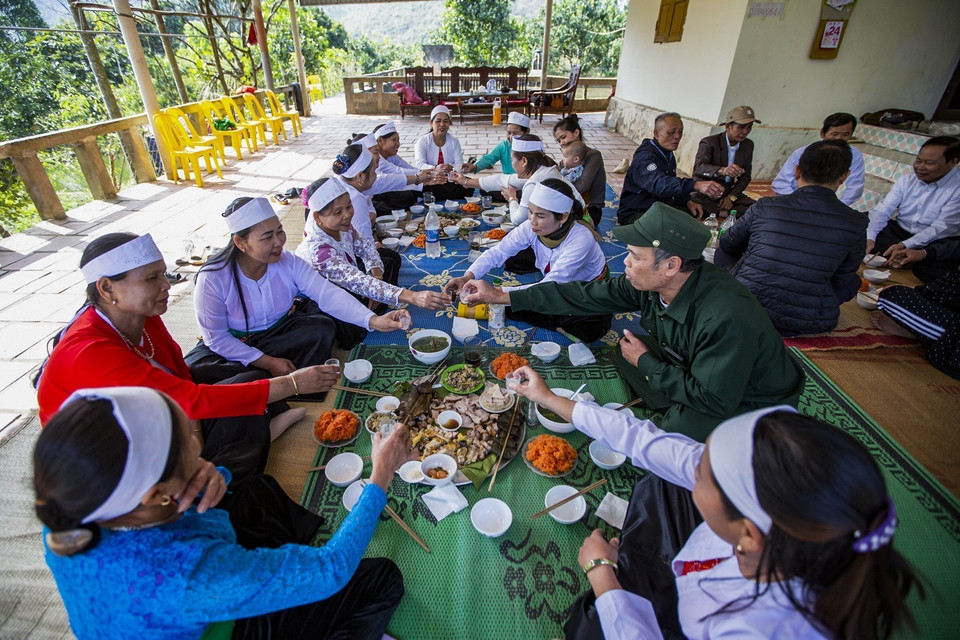 Gia chủ sau khi được chúc tết sẽ mời phường bùa vào, lên nhà sàn uống chén rượu xuân vui năm mới cùng gia đình. (Ảnh Trọng Đạt/TTXVN)