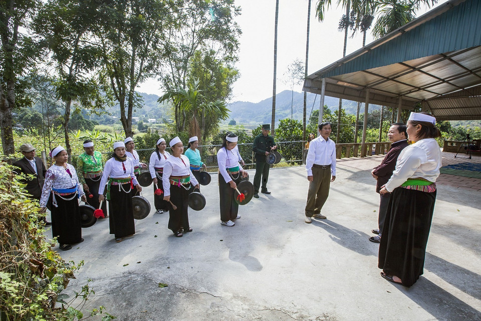 Đoàn đi đến đâu tấu chiêng xắc bùa đến đó, khi vào đến sân nhà ai ông trùm phường cất bài hát chúc Tết gia đình, sau đó gia chủ xuống sân mời phường bùa lên nhà uống chén rượu xuân. (Ảnh Trọng Đạt/TTXVN)