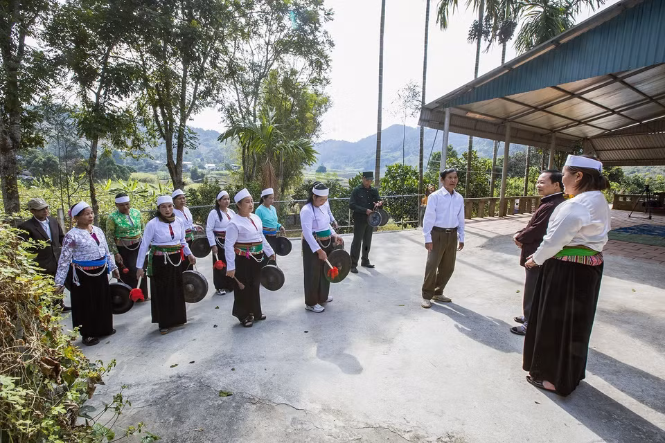 Đoàn đi đến đâu tấu chiêng xắc bùa đến đó, khi vào đến sân nhà ai ông trùm phường cất bài hát chúc Tết gia đình, sau đó gia chủ xuống sân mời phường bùa lên nhà uống chén rượu xuân. (Ảnh Trọng Đạt/TTXVN)