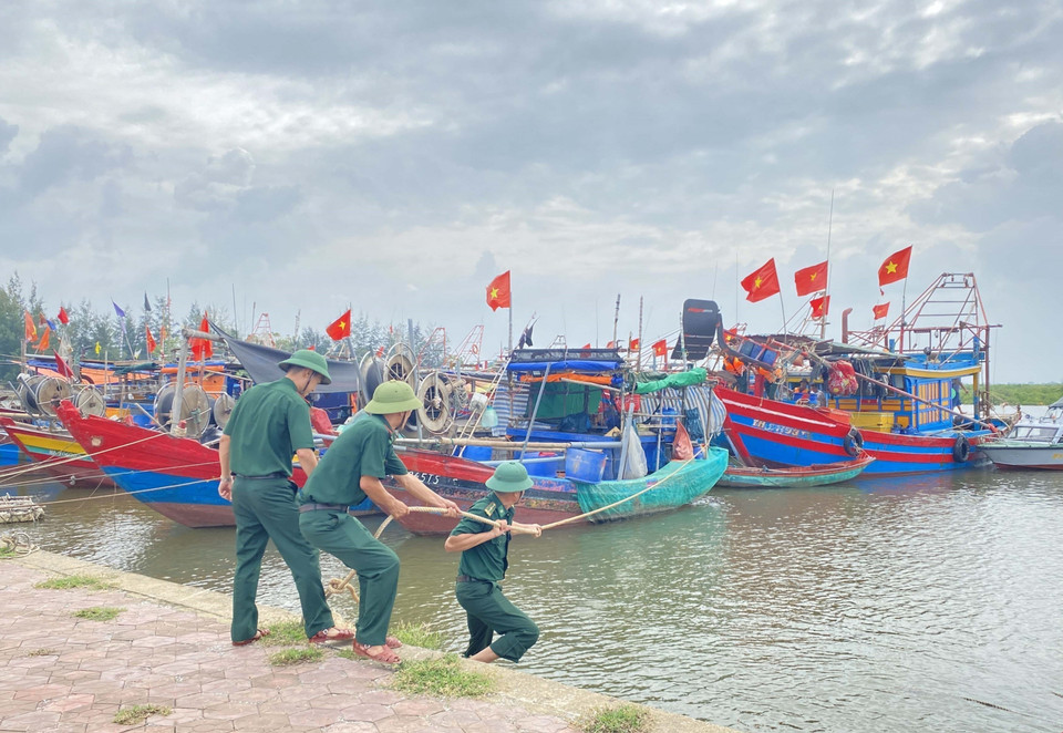 Cán bộ Đồn Biên phòng Cửa Sót (tỉnh Hà Tĩnh) hỗ trợ ngư dân chằng néo, neo đậu tàu thuyền. (Ảnh: Hữu Quyết/TTXVN)