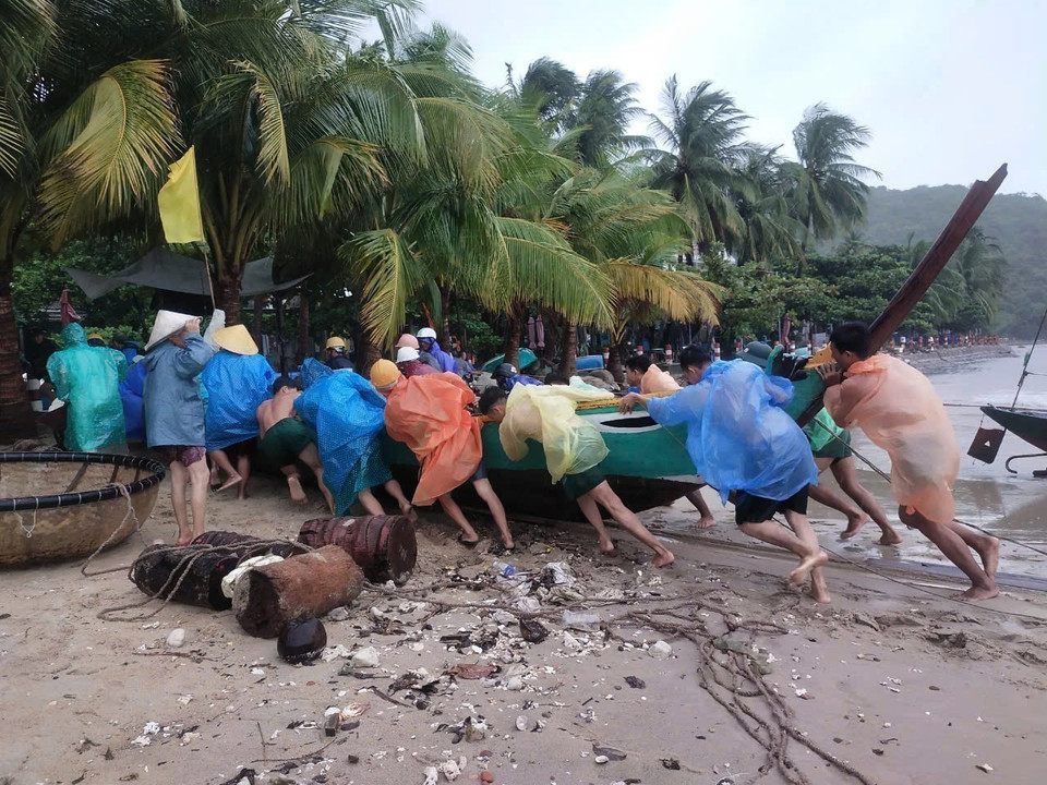 Cán bộ, chiến sỹ Đồn biên phòng Cửa Đại (Hội An) giúp ngư dân đưa phương tiện loại nhỏ đến nơi trú tránh an toàn. (Ảnh: Đoàn Hữu Trung/TTXVN)
