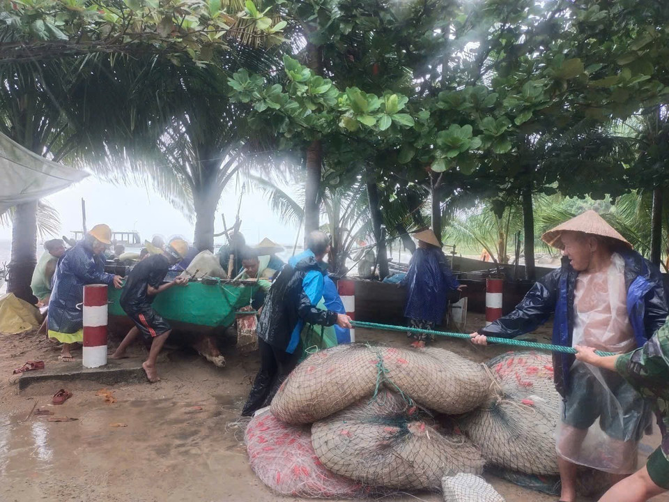 Cán bộ, chiến sỹ Đồn biên phòng Cửa Đại (Hội An) giúp ngư dân thu dọn ngư lưới cụ đề phòng thiệt hại. (Ảnh: Đoàn Hữu Trung/TTXVN)