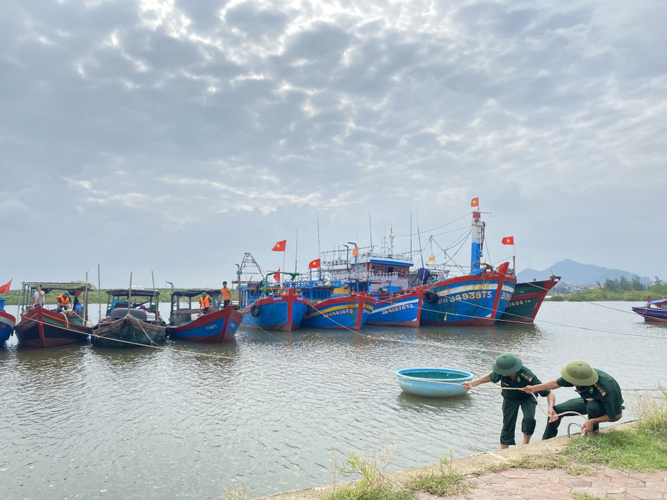 Cán bộ Đồn Biên phòng Cửa Sót hỗ trợ ngư dân chằng néo, neo đậu tàu thuyền. (Ảnh: Hữu Quyết/TTXVN)