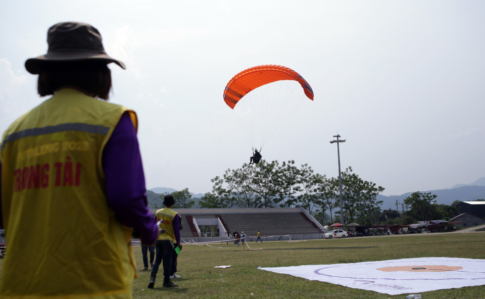 Phi công hạ cánh tại sân vận động thị trấn Tam Đường, tỉnh Lai Châu. (Ảnh: Quý Trung/TTXVN)