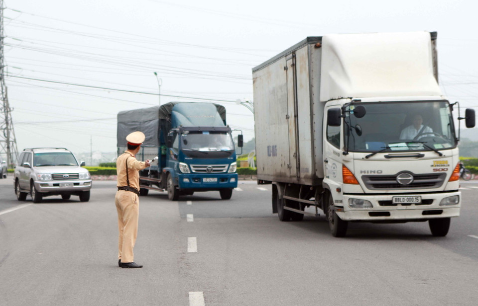 Cảnh sát giao thông tỉnh Vĩnh Phúc ra hiệu lệnh dừng phương tiện để kiểm tra trong ngày ra quân tại khu vực Trạm thu phí đường bộ quốc lộ 2 đoạn đi qua thành phố Vĩnh Yên. (Ảnh: Hoàng Hùng/TTXVN)