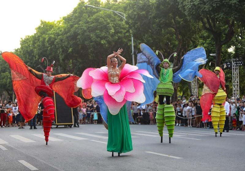 Các nghệ sỹ quốc tế trong trang phục rực rỡ và âm nhạc rộn ràng biểu diễn và diễu hành trên phố đi bộ Hồ Gươm.(Ảnh: Thanh Tùng/TTXVN)