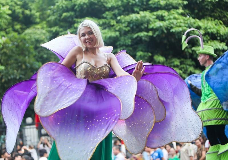 Các nghệ sỹ quốc tế trong trang phục rực rỡ và âm nhạc rộn ràng biểu diễn và diễu hành trên phố đi bộ Hồ Gươm.(Ảnh: Thanh Tùng/TTXVN)