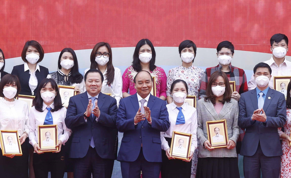 Hình ảnh Chủ tịch nước Nguyễn Xuân Phúc tặng ảnh chân dung Chủ tịch Hồ Chí Minh cho các cá nhân có thành tích xuất sắc của Tập đoàn Dệt may Việt Nam. (Ảnh: Thống Nhất/TTXVN)