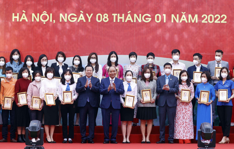 Chủ tịch nước Nguyễn Xuân Phúc tặng ảnh chân dung Chủ tịch Hồ Chí Minh cho các cá nhân có thành tích xuất sắc của Tập đoàn Dệt may Việt Nam. (Ảnh: Thống Nhất/TTXVN)