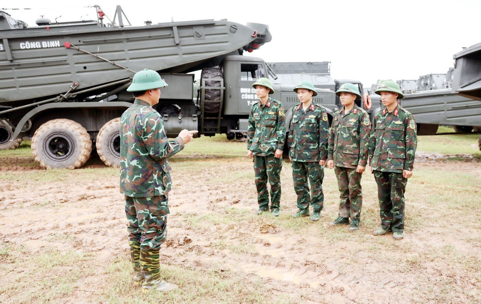 Các lực lượng chức năng bàn phương án lắp đặt cầu phao nhằm đảm bảo an toàn khi lắp đặt. (Ảnh: Tạ Toàn/TTXVN)