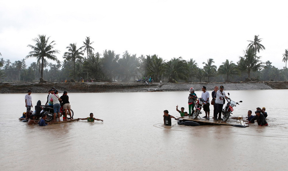 Người dân di chuyển bằng bè để qua sông sau bão Tembin tại tỉnh Lanao del Norte, Philippines ngày 23/12. (Nguồn: THX/TTXVN)