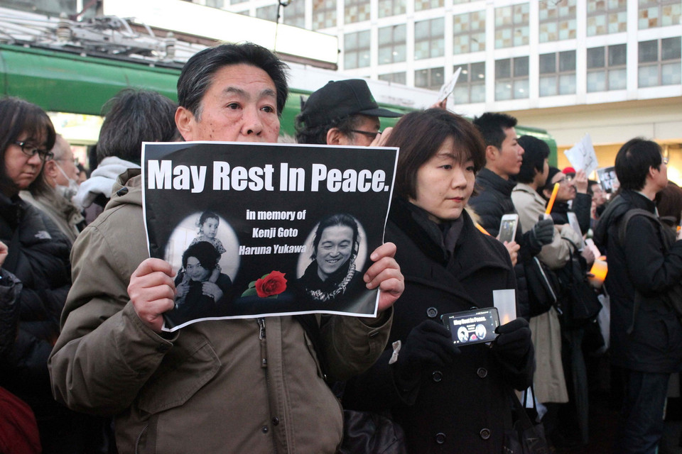 “Chúng tôi là Kenji,” “Kenji Goto và Haruna Yukawa, chúng tôi sẽ không bao giờ quên các anh”... là những khẩu hiệu được những người tham gia cầm chặt trên tay.(Ảnh: Hữu Thắng/Vietnam+)