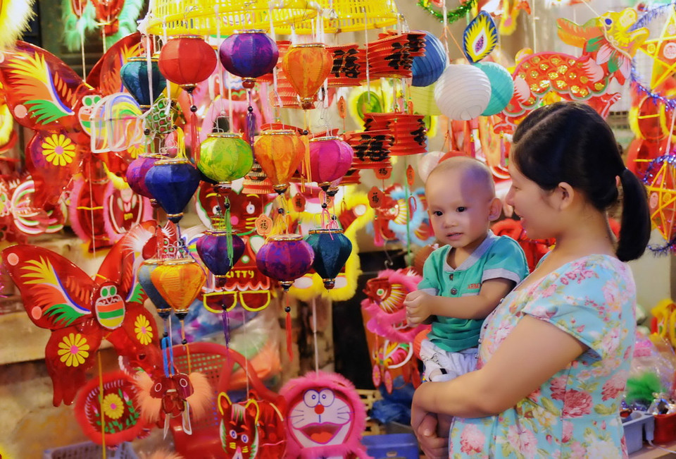 Các em thiếu nhi thích thú lựa chọn lồng đèn. (Ảnh: An Hiếu/TTXVN)