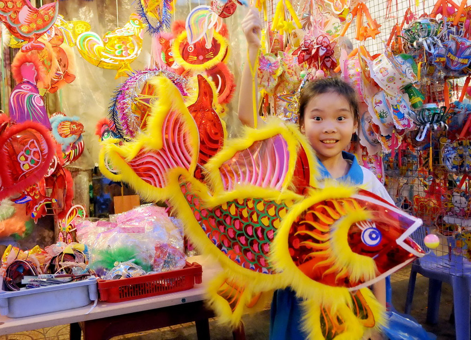 Các em thiếu nhi thích thú lựa chọn lồng đèn. (Ảnh: An Hiếu/TTXVN)