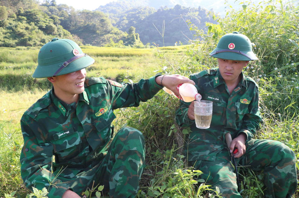 chiến sỹ Đồn Biên phòng Mường Pồn (Bộ đội Biên phòng tỉnh Điện Biên) trong những phút nghỉ giải lao sau nhiều giờ tham gia gặt lúa giúp dân. (Ảnh: Xuân Tiến/TTXVN)