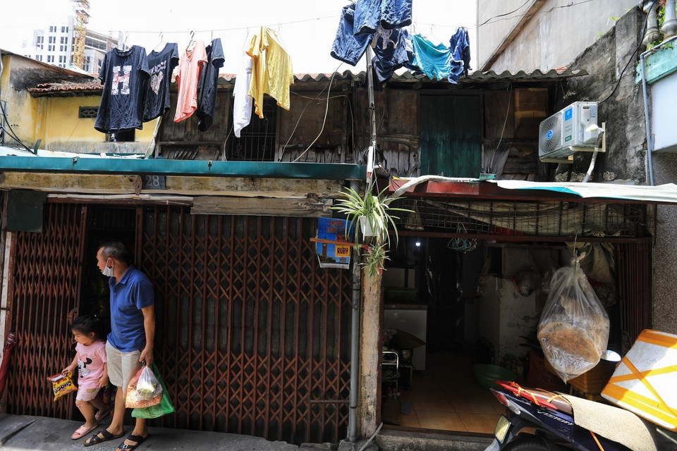 Người dân sống dưới tầng 1 vẫn phải sinh hoạt dù trên đầu là những căn hộ gỗ đã xuống cấp nghiêm trọng, không biết ngày nào đổ sập. (Ảnh: Thành Đạt/TTXVN)