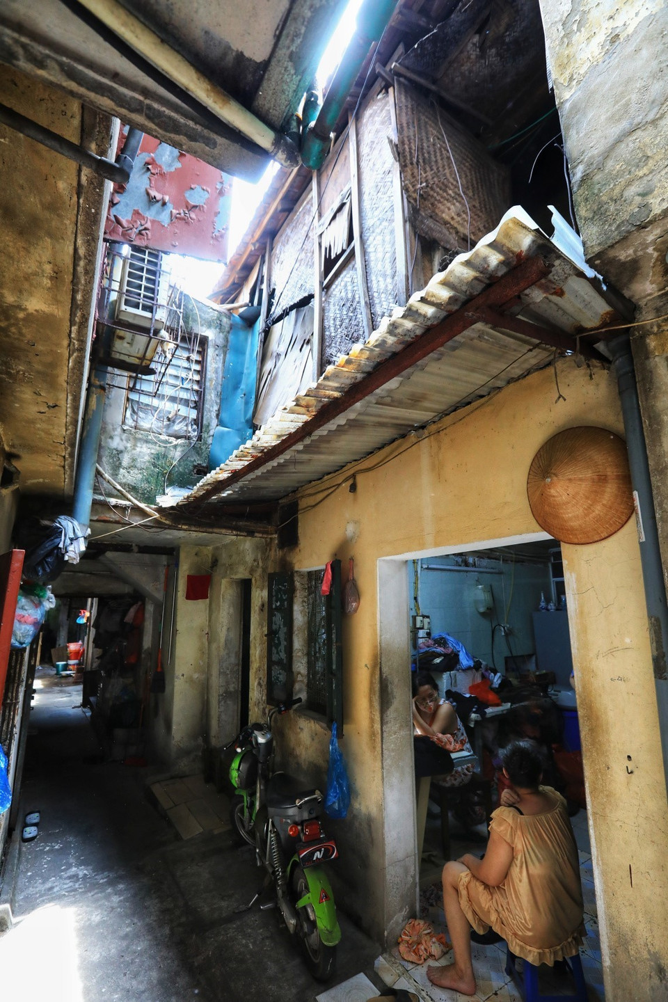 Người dân sống dưới tầng 1 vẫn phải sinh hoạt dù trên đầu là những căn hộ gỗ đã xuống cấp nghiêm trọng, không biết ngày nào đổ sập. (Ảnh: Thành Đạt/TTXVN)