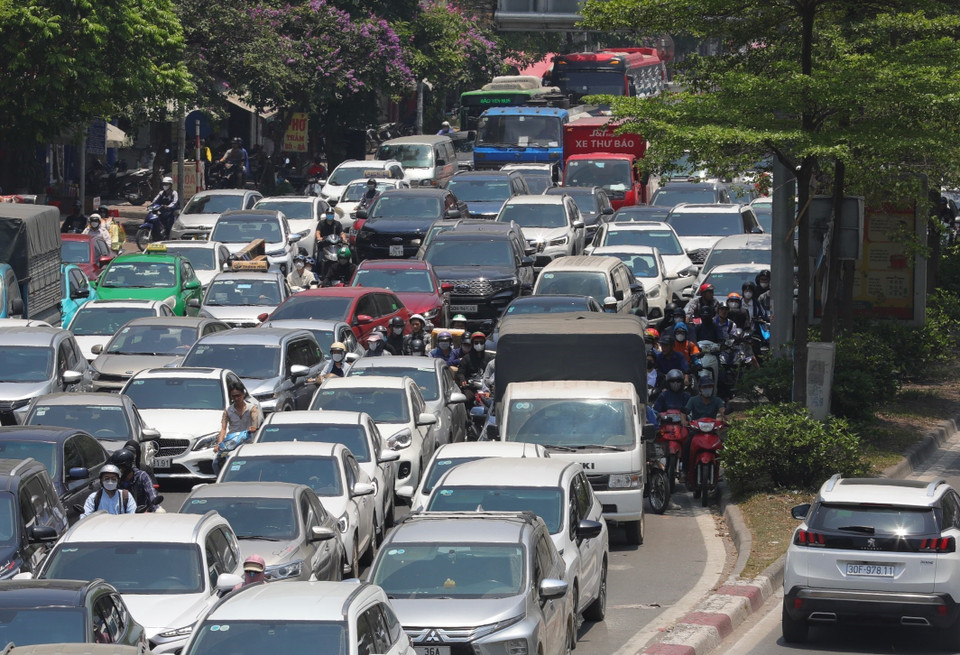 Nhiều người và phương tiện di chuyển trên phố Trường Chinh cố tìm những nơi có bóng mát để dừng đỗ, chờ đèn giao thông. (Ảnh: Hoàng Hiếu/TTXVN)