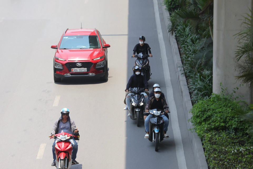 Nhiều người dân đi trên đường Nguyễn Trãi đã chọn những nơi có bóng râm để di chuyển. (Ảnh: Hoàng Hiếu/TTXVN)