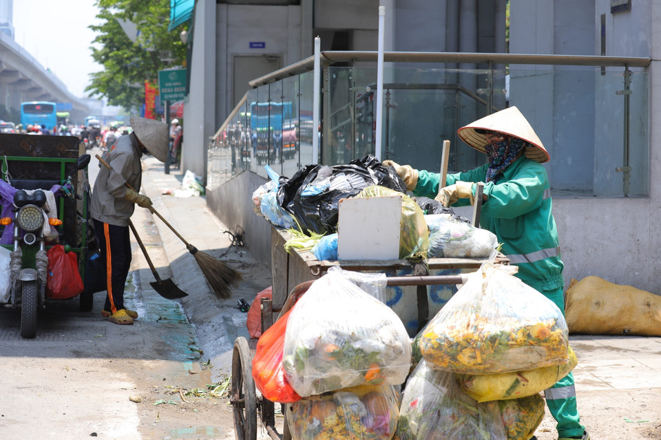 Nhân viên vệ sinh Hợp tác xã Vệ sinh Thành Công làm việc dưới nắng nóng gay gắt (ảnh chụp lúc 12h10 trên phố Nguyễn Trãi).(Ảnh: Hoàng Hiếu/TTXVN)