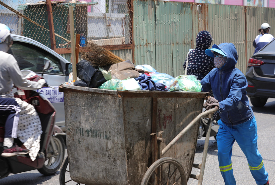 Công nhân Công ty Urenco 4 vẫn cần mẫn làm việc dưới cái nắng nóng trên 40 độ (ảnh chụp lúc 12h30 phố Chùa Bộc).(Ảnh: Hoàng Hiếu/TTXVN)
