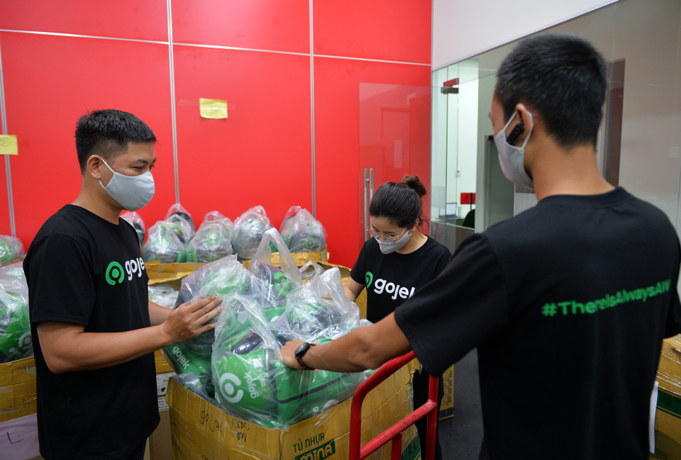 Từ nhiều ngày nay hàng chục nghìn bộ trang bị mới với thương hiệu Gojek được các nhân viên kiểm tra và chuẩn bị cho các đối tác tài xế công nghệ của hãng gồm gồm đồng phục, mũ bảo hiểm và túi GoFood để giao nhận đồ ăn. (Ảnh: PV/Vietnam+)