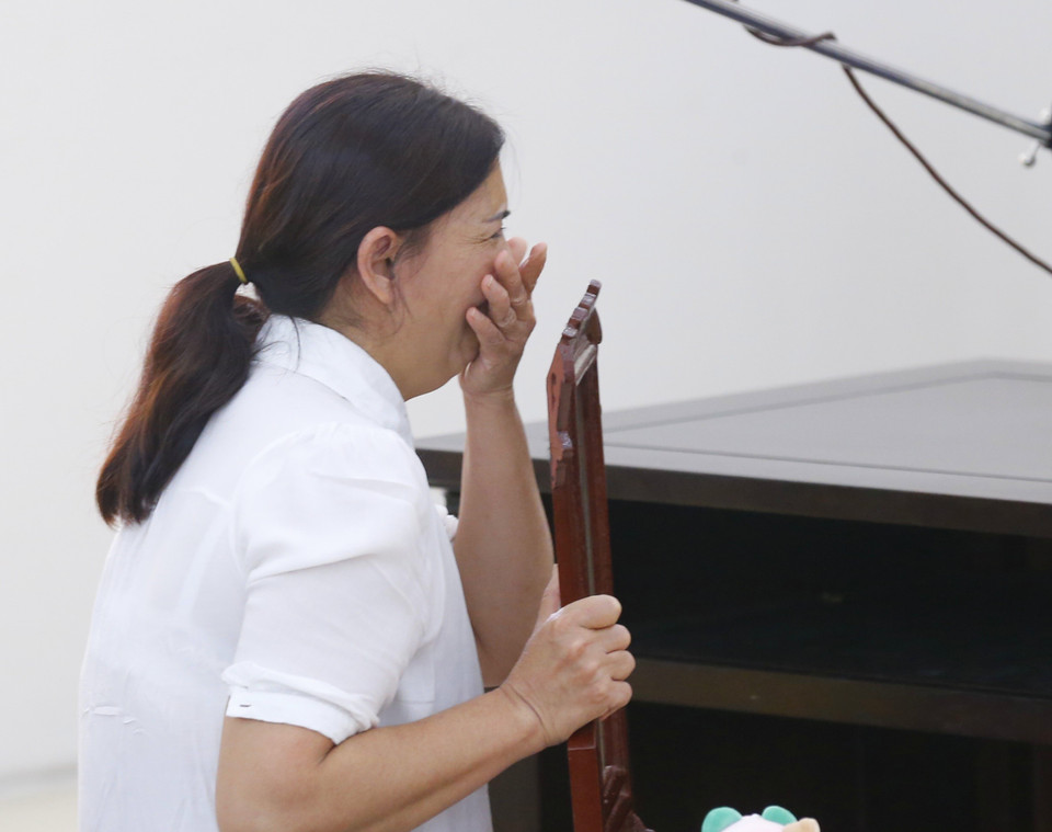 Người nhà cháu bé cầm di ảnh bật khóc tại phiên tòa. (Ảnh: Doãn Tấn/TTXVN)