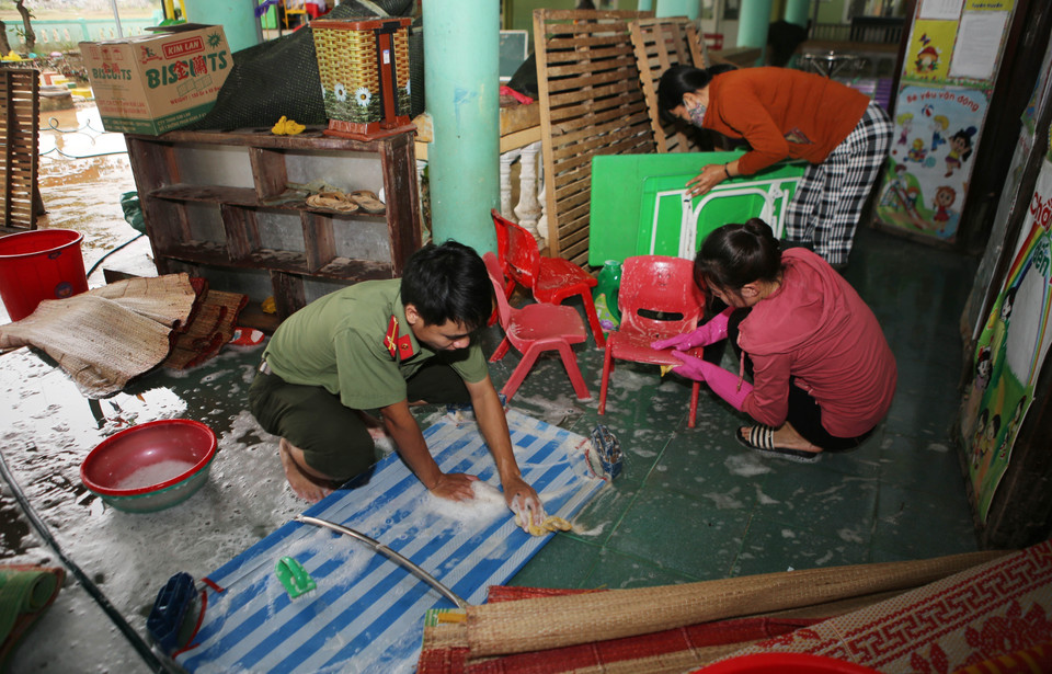 Chiến sỹ công an cùng thầy, cô giáo các trường học vùng thấp trũng ở huyện Triệu Phong (Quảng Trị) vệ sinh trường lớp, sẵn sàng đón học sinh đi học trở lạ sau khi nước lũ rút (15/10/2020). (Ảnh: Hồ Cầu/TTXVN)