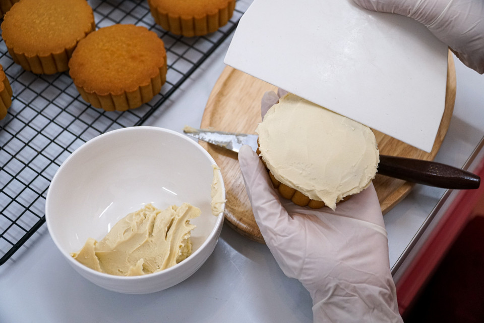 Chính vì vậy, cô chủ tiệm bánh lựa chọn đậu xanh và đậu trắng để làm nền vẽ bởi nền đậu vừa dễ làm và giữ được màu lâu. Mặc dù những bức vẽ đầu tiên cũng bị hỏng rất nhiều do nền đậu mềm hơn trên giấy nên nét vẽ bị to và thô nhưng qua thời gian luyện tập hiện cô có thể làm một cách thuần thục và dễ dàng. (Ảnh: Minh Hiếu/Vietnam+) 