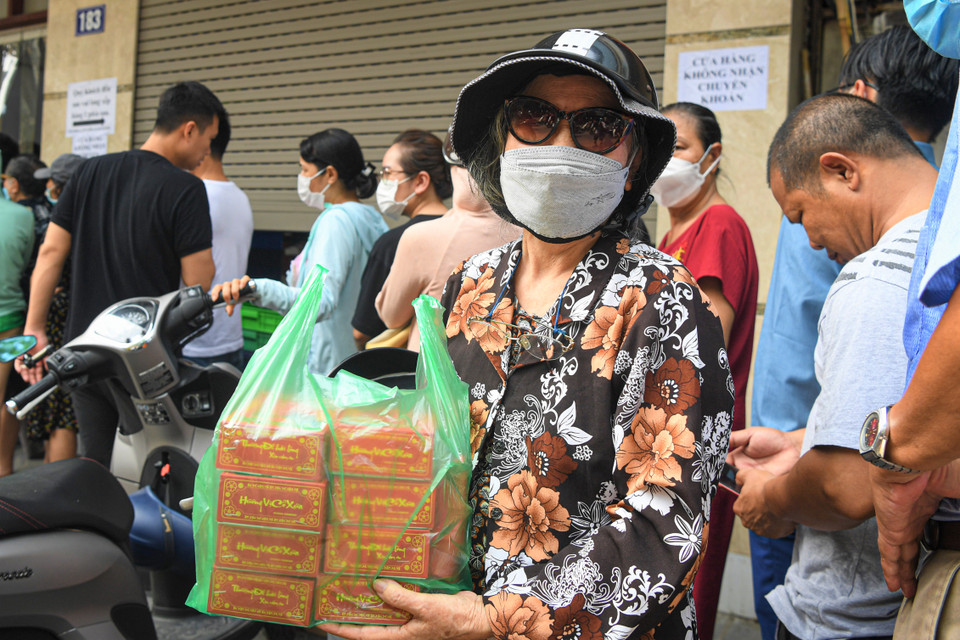 Bà Thu (quận Cầu Giấy, Hà Nội) mua được túi bánh sau hơn một giờ chờ đợi. "Bánh Trung Thu tại Thụy Khuê có cái hương vị xưa mà chúng tôi thích, còn lớp trẻ thì chẳng thích kiểu này đâu," bà Thu cười nói. (Ảnh: PV/Vietnam+)