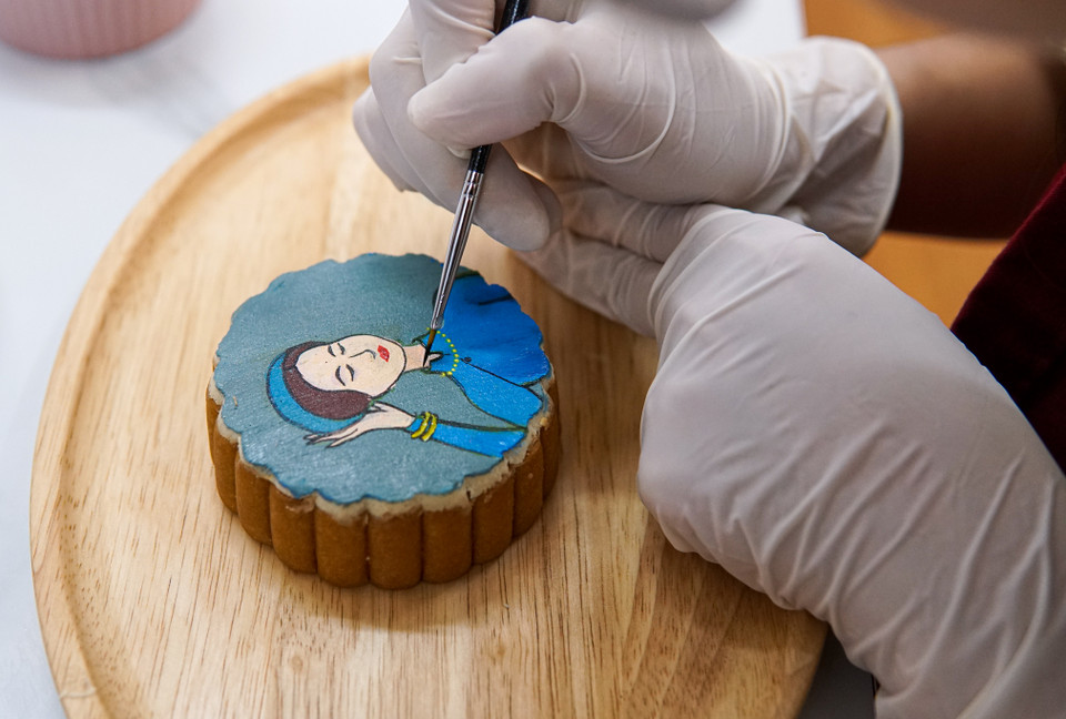 Tùy từng chủ đề mà thời gian vẽ sẽ khác nhau, với mẫu vẽ đơn giản thì Dương chỉ mất khoảng 5 phút để hoàn thiện. Một số mẫu cầu kỳ, nhiều họa tiết mất từ 20-40 phút cho một chiếc bánh. (Ảnh: Minh Hiếu/Vietnam+)