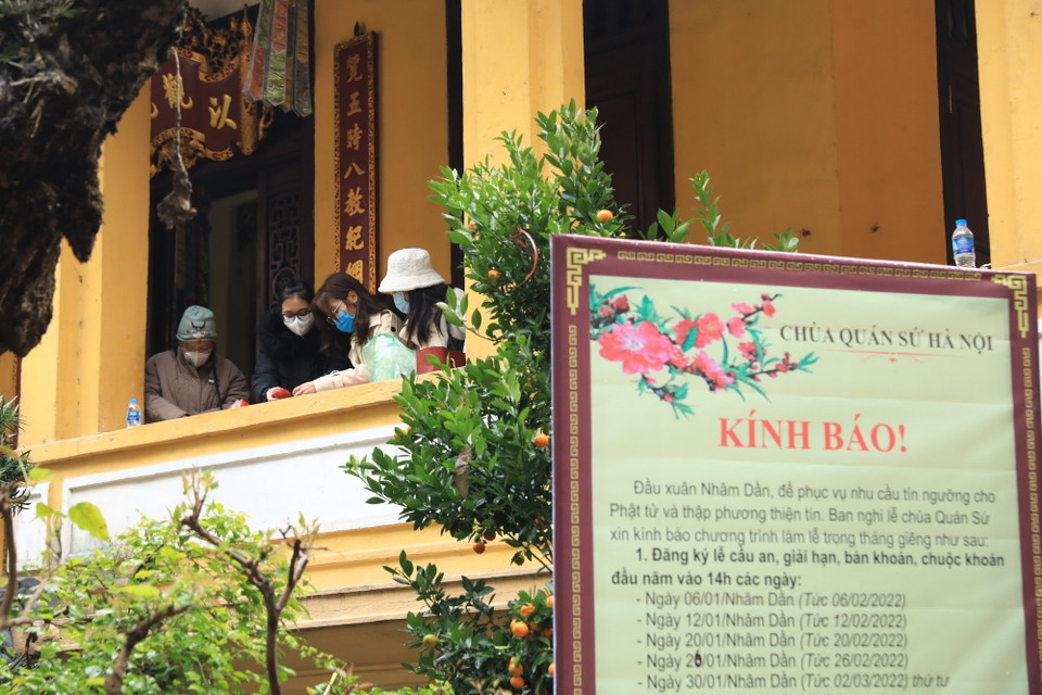 Người dân chuẩn bị lễ vật trước khi vào lễ tại chùa Quán Sứ sáng 13/2. (Ảnh: Hoàng Hiếu/TTXVN)