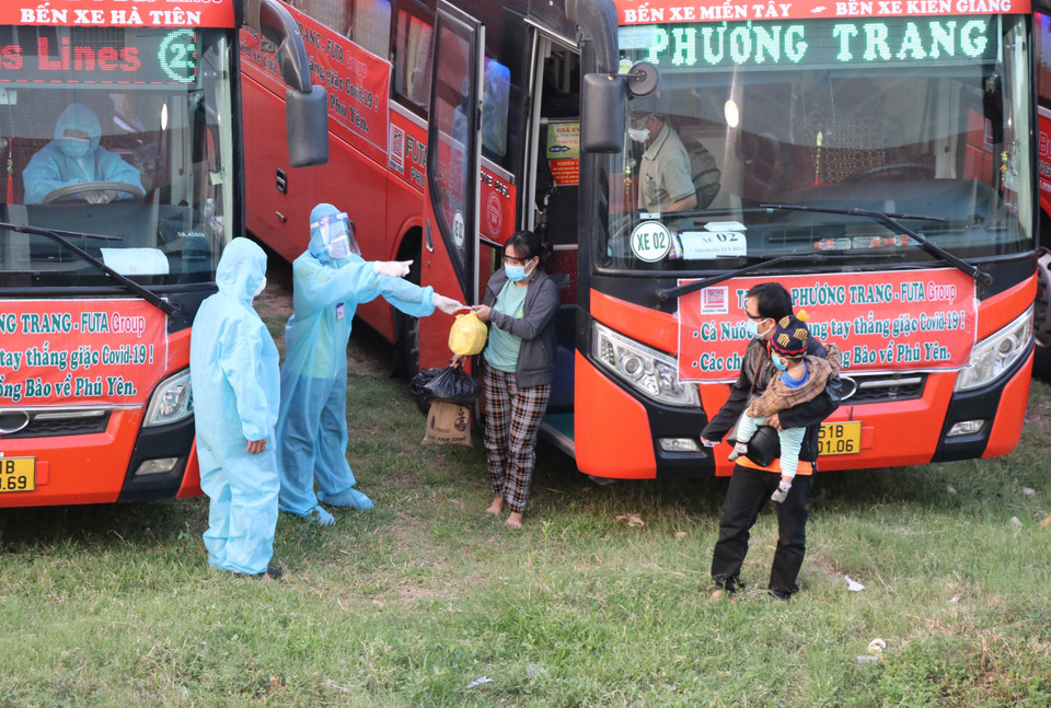 Công dân xuống xe được phát phiếu, số thứ tự và hướng dẫn đến khu vực lấy mẫu PCR xét nghiệm. (Ảnh: Phạm Cường/TTXVN)