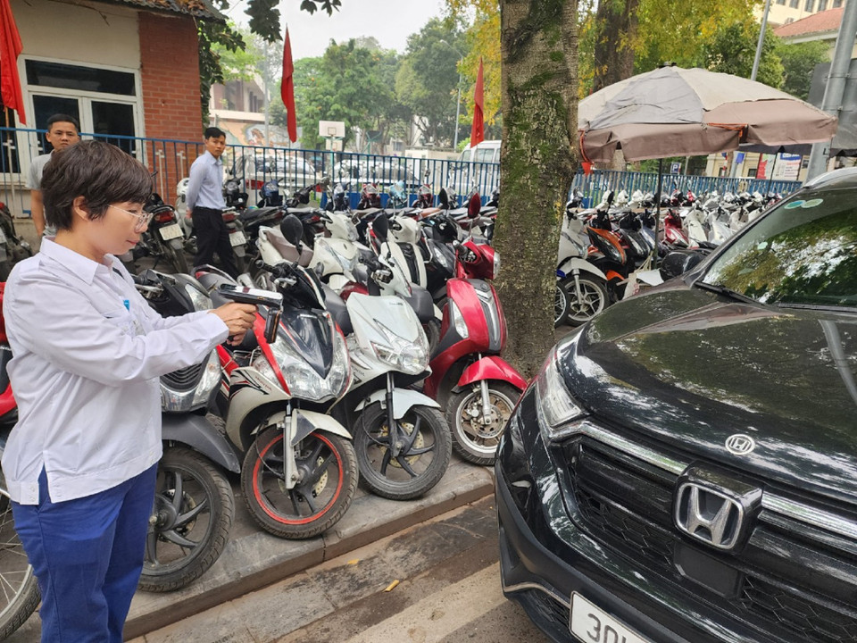 Tại điểm trông giữ xe dưới lòng đường, nhân viên trông giữ sẽ dùng thiết bị cầm tay để nhận diện thẻ Etag định danh gắn trên phương tiện. (Ảnh: Việt Hùng/Vietnam+)