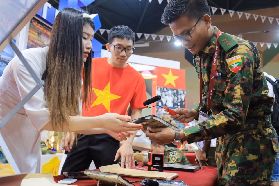 Sỹ quan trẻ của Đoàn quân đội Myanmar tự tay làm tranh dân gian Đông Hồ để mang về làm quà cho người thân ở quê nhà. (Ảnh: Trần Hiếu/TTXVN)