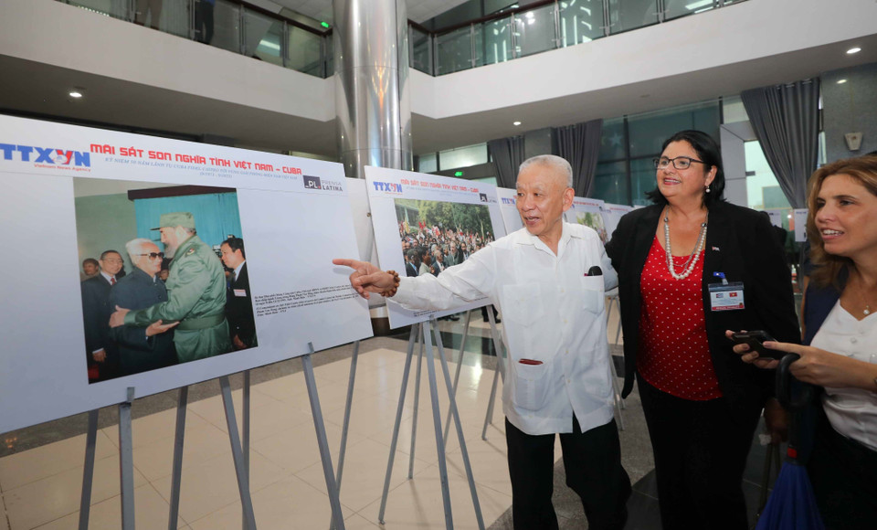 Nhân chứng trong bức ảnh tại Trưng bày vui mừng kể về kỷ niệm với Lãnh tụ Cuba Fidel Castro. (Ảnh: Thanh Tùng/TTXVN) 