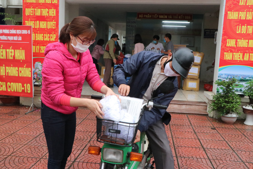 Các trưởng khu dân cư của phường Phạm Ngũ Lão, thành phố Hải Dương nhận vật phẩm do TTXVN và Tỉnh đoàn Hải Dương ủng hộ. (Ảnh: Mạnh Minh/TTXVN)