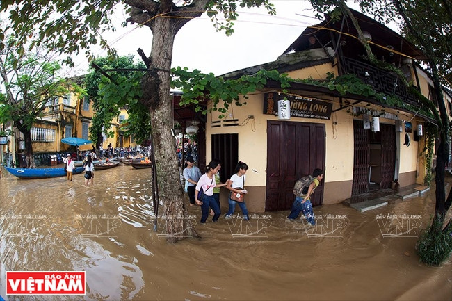 Học sinh men theo bờ tường các dãy phố về nhà sau buổi học. (Nguồn: Báo ảnh Việt Nam)